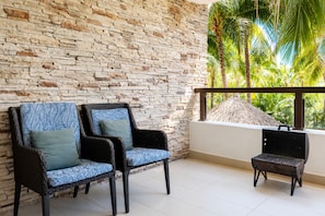A balcony with wicker chairs and a grill, overlooking a tropical garden. - Luxury Family Resort & Beach Club  (Acapulco de Juárez)