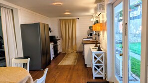 Uma cozinha compacta com geladeira, fogão e área de refeições.