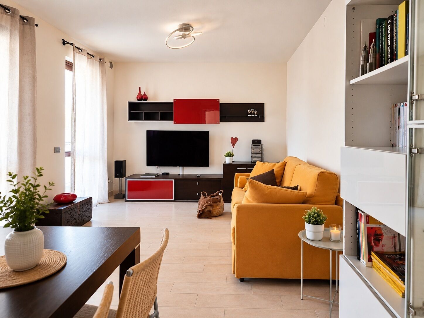 Uma sala de estar moderna com um sofá, TV e uma estante.