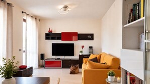 Uma sala de estar moderna com um sofá, TV e uma estante.