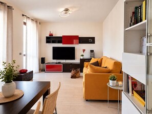 Ein modernes Wohnzimmer mit einer Couch, einem Fernseher und einem Bücherregal.