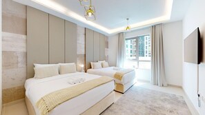 Ein modernes Hotelzimmer mit zwei Betten, einem großen Fenster und einem Flachbildfernseher.