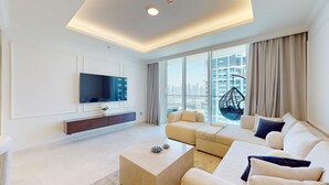 A modern living room with a flat-screen TV, a sofa set, a hanging chair, and a city view through large windows. - Aesthetic 1 Bed l Overlooking Marina City Skyline (Dubai)