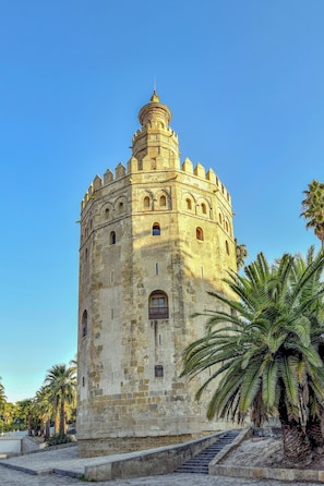 A historic stone tower with a dome, arched windows, and a staircase leading up to the entrance.
