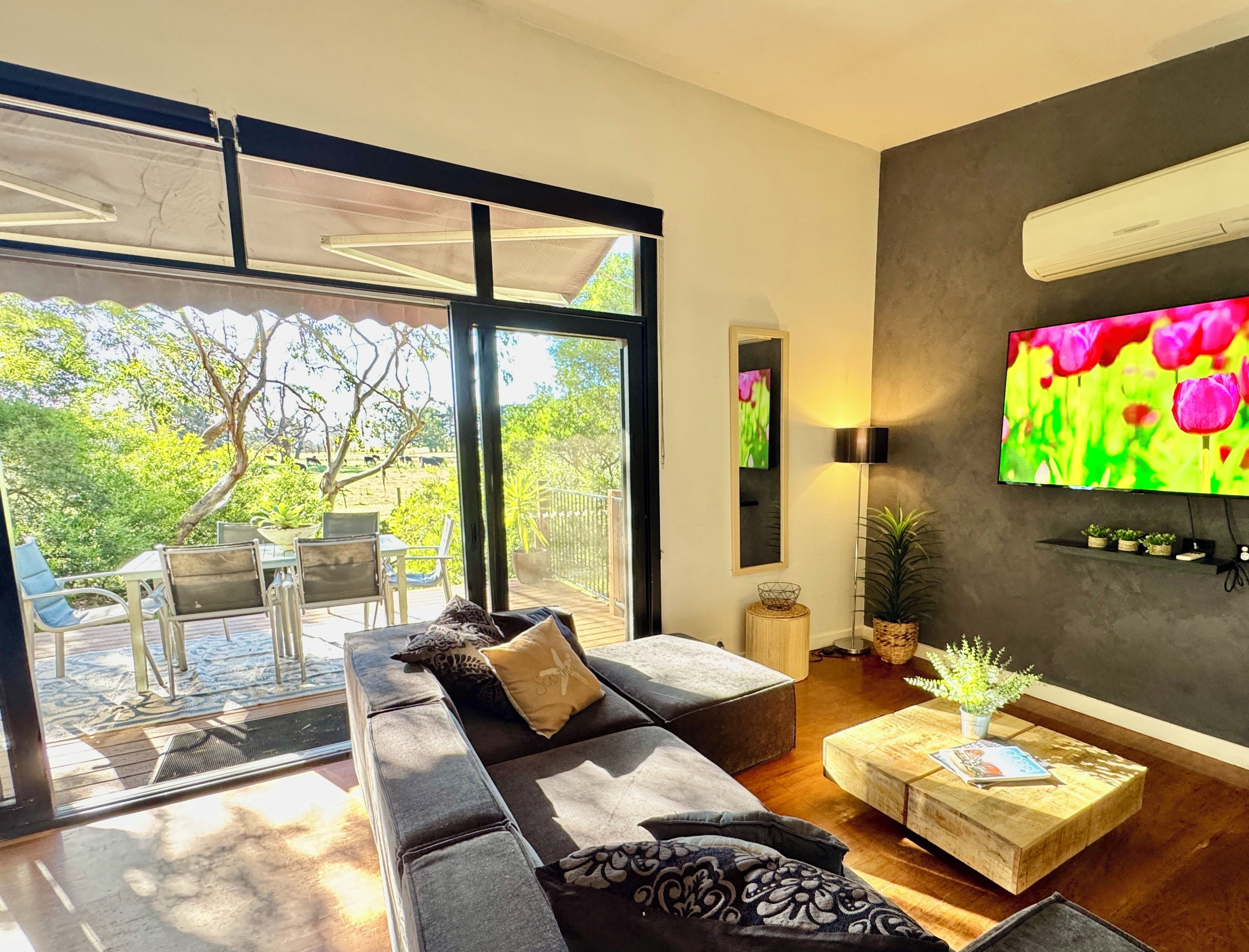 A modern living room with a large sofa, a coffee table, and a TV.