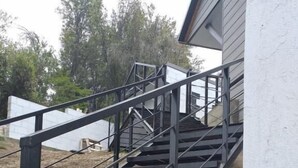 A set of outdoor metal stairs leading up to a building. - Complejo Moquehue (Villa Pehuenia)