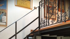 A staircase with a wrought iron railing, a radiator, and a framed picture on the wall. - Casa Raffaello, just a stone's throw from the sea. Complete relaxation and tranquility. (Sicilia)