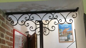 A staircase with a metal railing, a brick wall, and a poster on the wall. - Casa Raffaello, just a stone's throw from the sea. Complete relaxation and tranquility. (Sicilia)