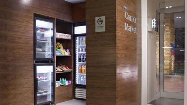 Une petite épicerie de quartier aux murs en bois, avec un panneau indiquant qu’il est interdit de fumer à l’intérieur.