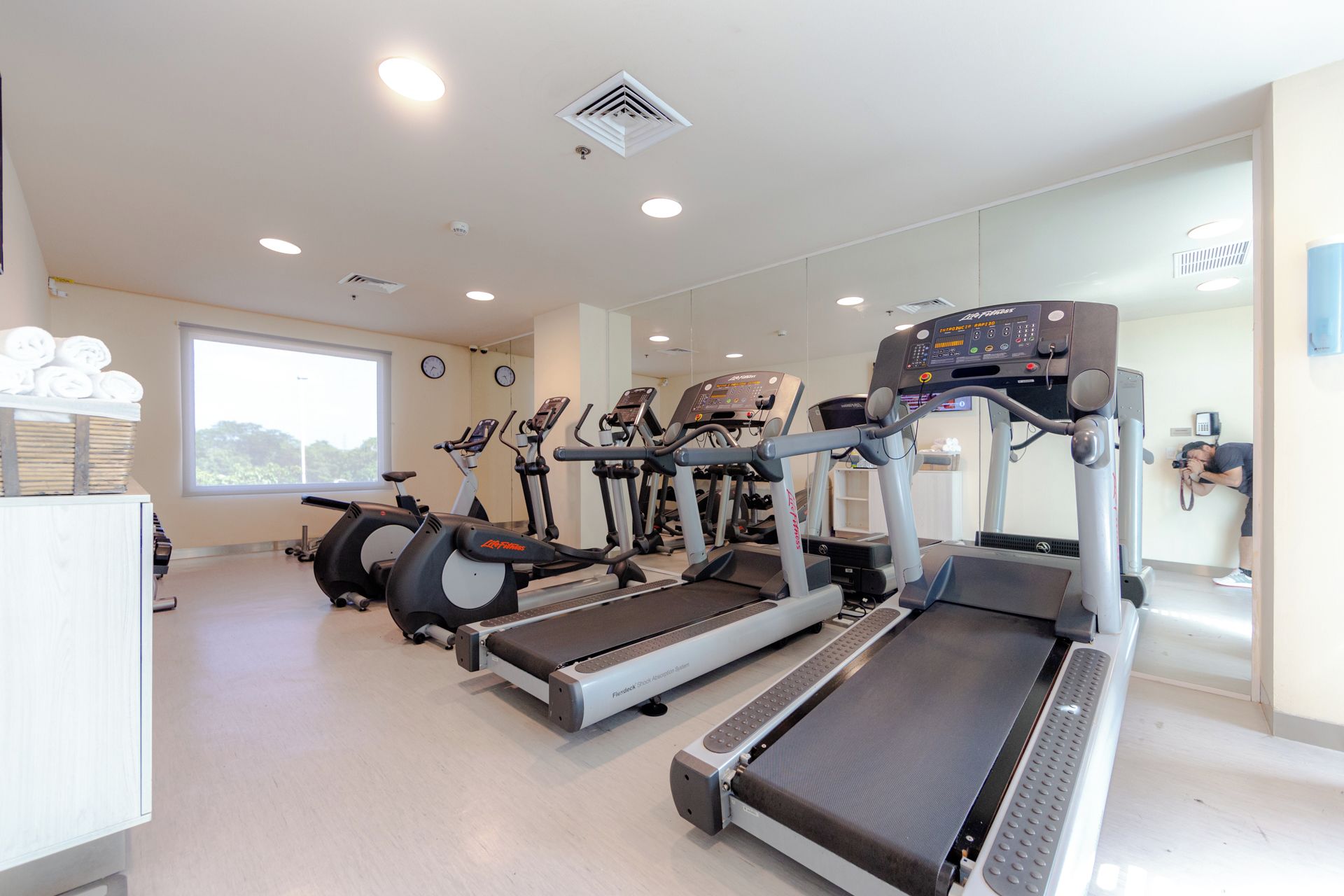 A gym with treadmills, stationary bikes, and a rowing machine.