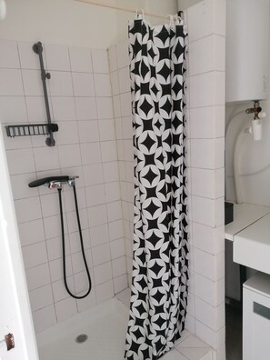 Une salle de bain avec une douche, des toilettes et un lavabo.