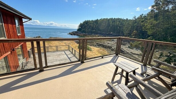 A wooden deck with a view of the ocean and forest. - Oceanfront Suite with Private Deck & Ensuite Bath - Rm 11 (Gabriola)