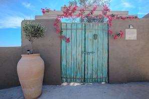 A turquoise gate with a keyhole, a potted plant, and a sign with 'AER' on a wall. - Romantic Private Pool Villa with Spectacular 180° Ocean Views (Korissia)