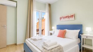 Ein Hotelzimmer mit einem Bett, einem Nachttisch, einer Lampe, einem Gemälde und einer Schiebetür.