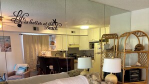 A living room with a sofa, a coffee table, a lamp, and a bookshelf. - Cozy Beach Escape (Ocean City)