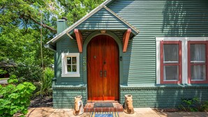 A house with a wooden front door, a small window, and a brick entrance step. - Perla's Place - Fire Place & 3 Blocks from Main (Fredericksburg)
