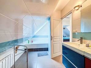 Ein modernes Badezimmer mit Badewanne, Dusche und Waschtisch mit Spiegel.