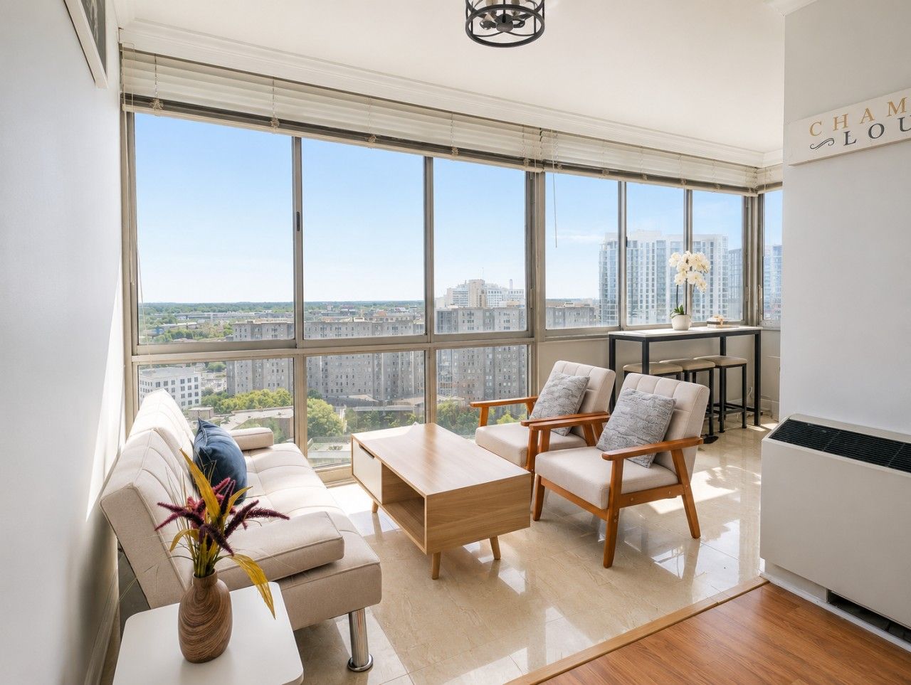 A modern living room with a large window, a sofa, a coffee table, and a chair.