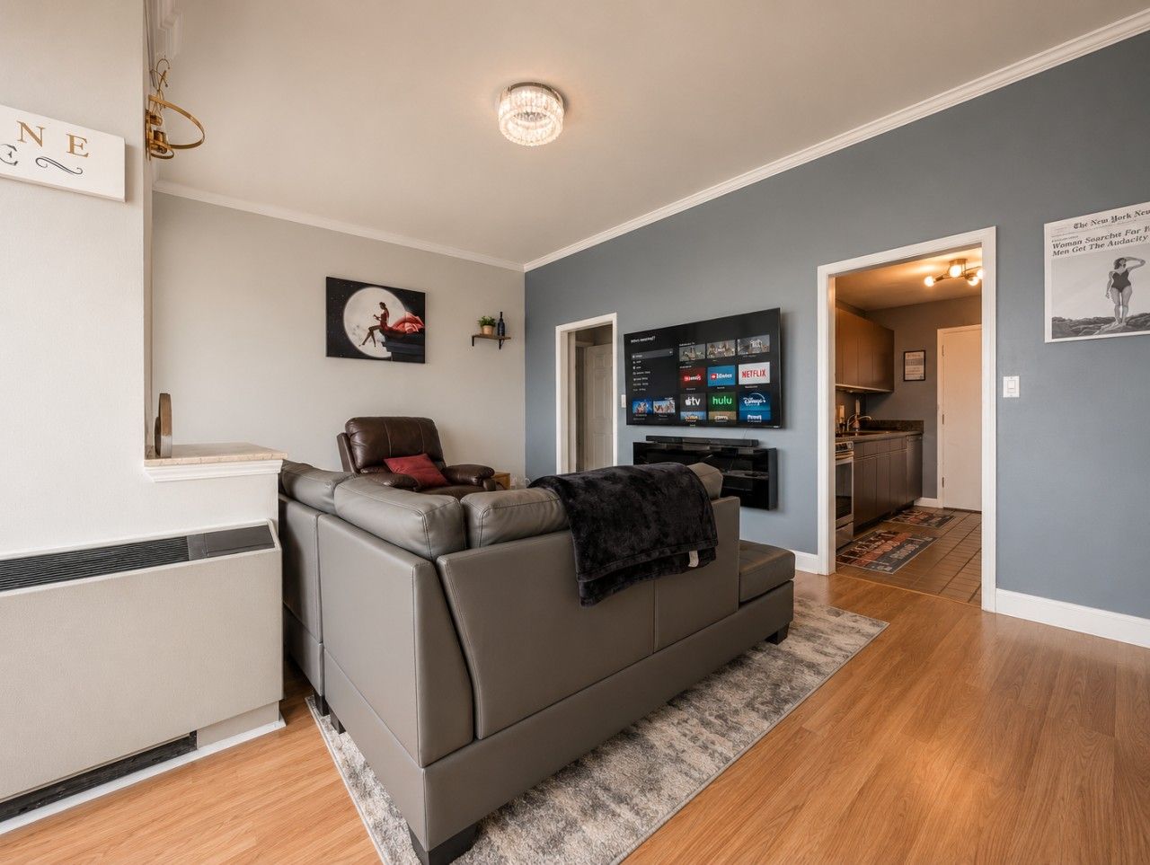 A living room with a grey sofa, a flat-screen TV, and a fireplace.