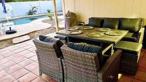 An outdoor patio with wicker furniture, a pool, and a covered area. - Tempe Oasis w Pool, Spa and Garage! (Tempe)