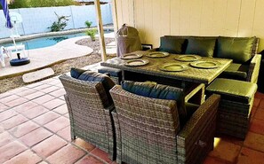 An outdoor patio with wicker furniture, a pool, and a covered area. - Tempe Oasis w Pool, Spa and Garage! (Tempe)
