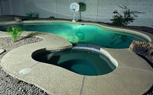 A swimming pool with a curved design, a basketball hoop, and a small palm tree. - Tempe Oasis w Pool, Spa and Garage! (Tempe)