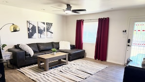 A modern living room with a sofa, coffee table, and a rug. - Tempe Oasis w Pool, Spa and Garage! (Tempe)