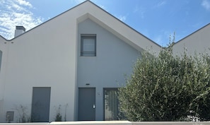 A modern building with a flat roof, a small window, and a door with an access control panel. - Home Sweet Home. (Parchal)