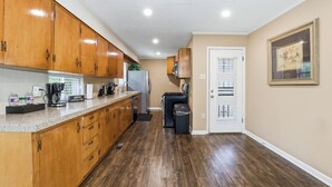 A kitchen with wooden cabinets, a stainless steel refrigerator, and a coffee maker.