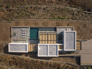 Ein modernes Gebäude mit Pool, Sitzgelegenheiten im Freien und einer Steinschmalseite.