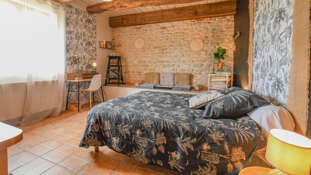 Een slaapkamer met een bed, een bureau en een stoel.