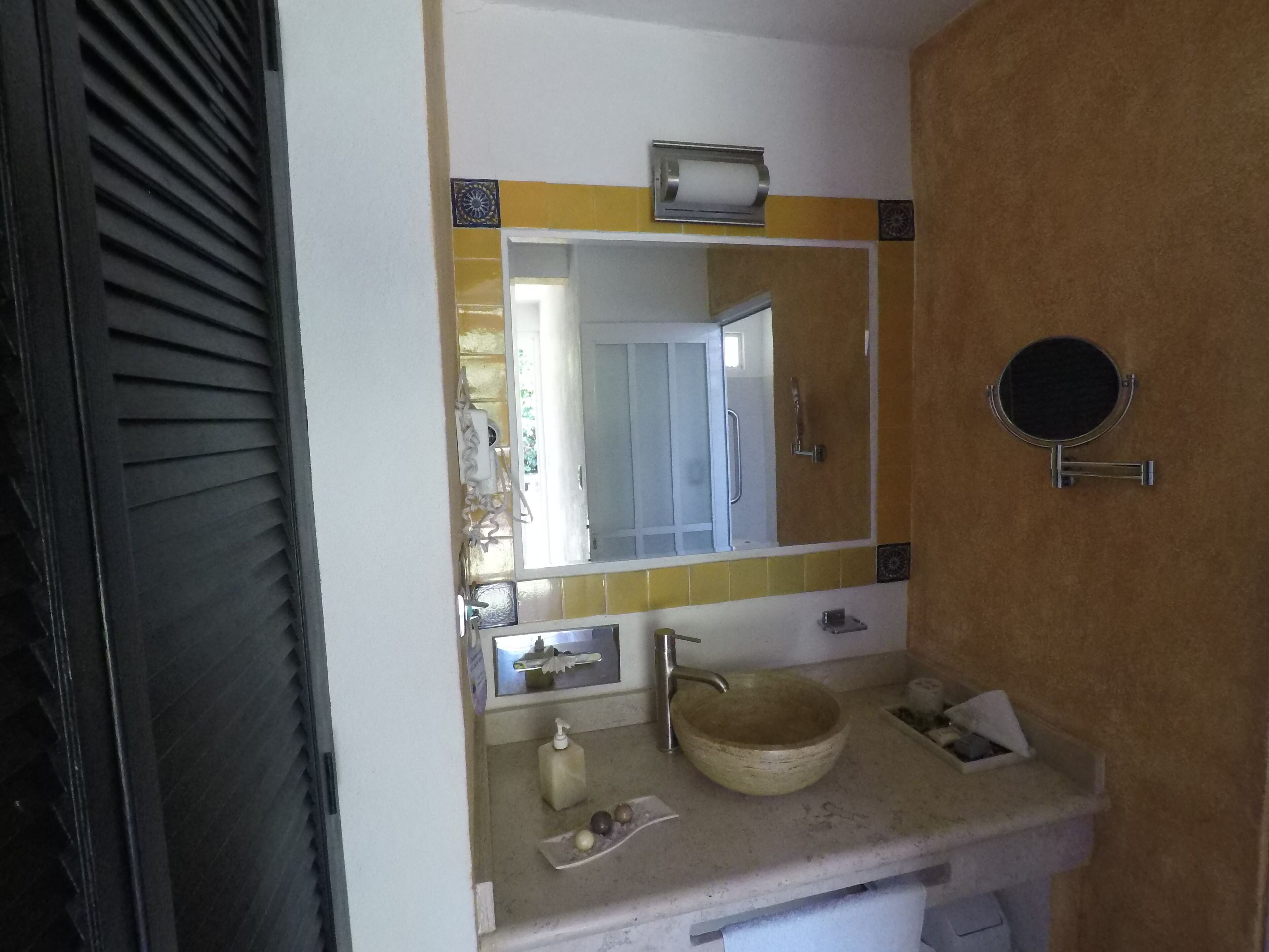 A bathroom with a sink, mirror, and towel rack.
