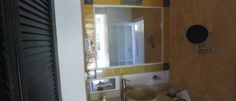 A bathroom with a sink, mirror, and towel rack.