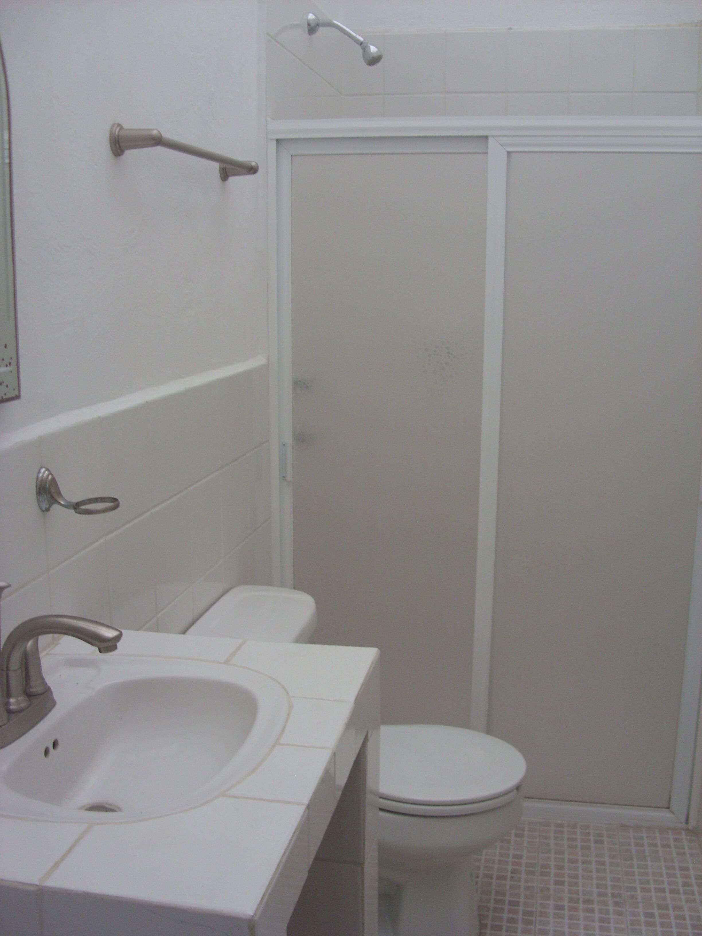 A bathroom with a sink, toilet, and shower.