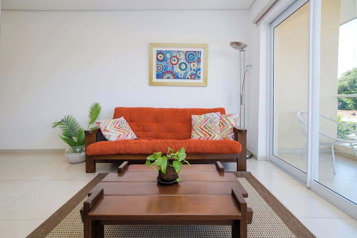 A modern living room with a sofa, a coffee table, and a potted plant.