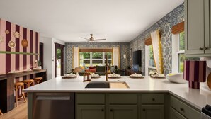 A kitchen with striped wallpaper, a ceiling fan, and a window with curtains. - Boutique 4BR Retreat w/Swim Spa • Sauna • Fire Pit (Georgetown)