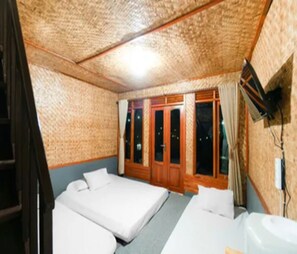 Ein Zimmer mit zwei Betten, einer Holztür und einem Fenster.