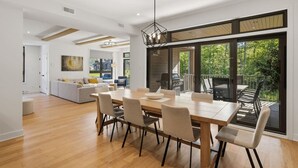 Ein modernes Interieur mit Essbereich, einer Küche und einem Balkon mit Gartenmöbeln.