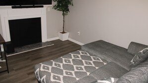 A living room with a fireplace, a sofa, a coffee table, and a potted plant. - Serene 1-bedroom house in charming Lithonia (Lithonia)