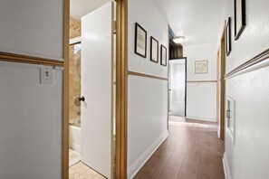 A hallway with white walls, wooden trim, and a tiled floor. - Main House Santa Clarita Retreat+Pets with fee (Santa Clarita)