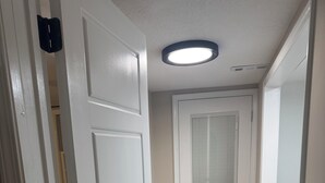 A hallway with a white door, a ceiling light, and a wooden floor. - Close to SRP park the medical district and Fort Gordon (North Augusta)