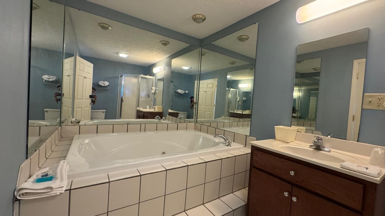 Une salle de bain avec une grande baignoire, un meuble-lavabo avec un miroir et des toilettes.