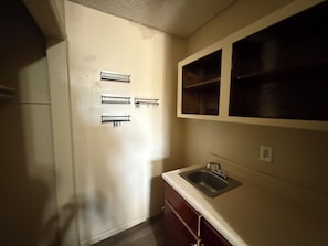 A kitchen with a sink, cabinets, and a window above the counter.