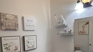 Ein Badezimmer mit Toilette, Waschbecken und Regalen an der Wand.