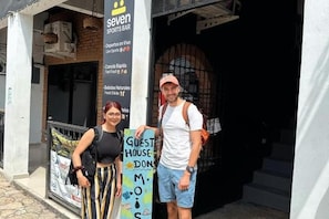 Entrada de um edifício com uma placa indicando 'Seven Sports Bar' e uma placa de pousada.