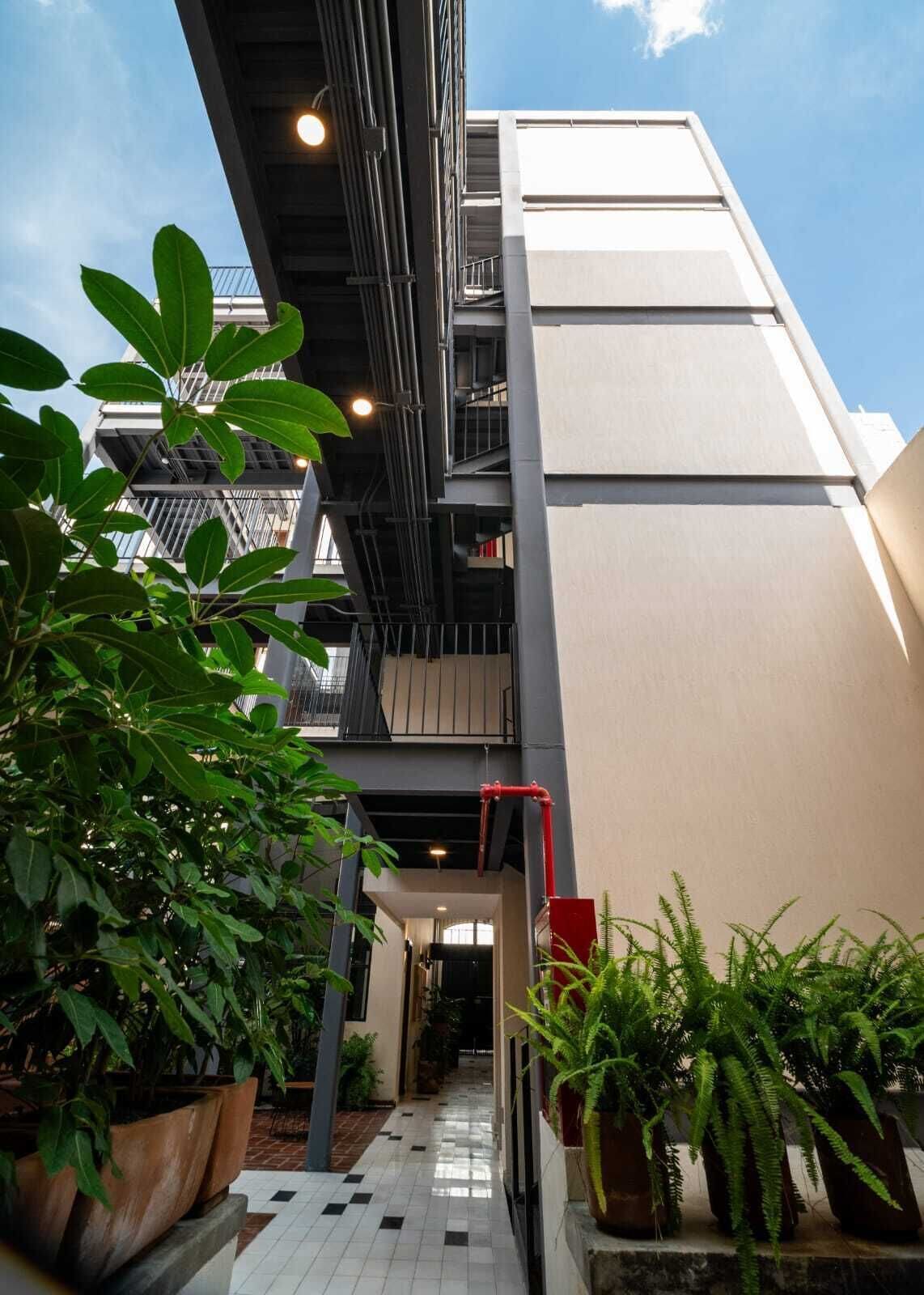 Un edificio moderno con escalera, plantas en macetas y suelo de baldosas.