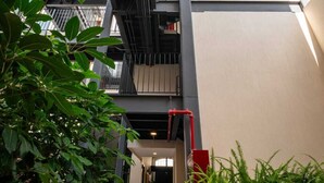 Un bâtiment moderne doté d’un escalier, de plantes en pot et d’un sol carrelé.