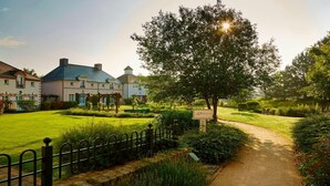 A well-maintained garden with a pathway leading to a building with a sign reading 'la Treille.'