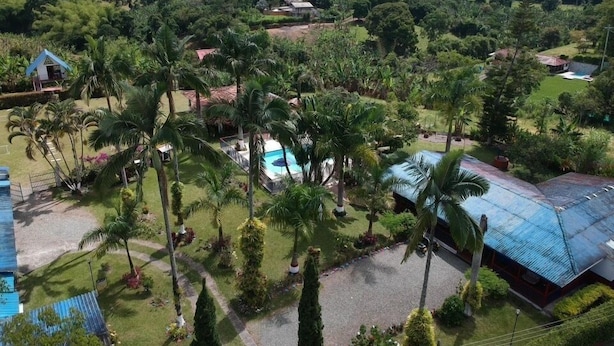 Un resort con piscina, palmeras y vistas del paisaje circundante.
