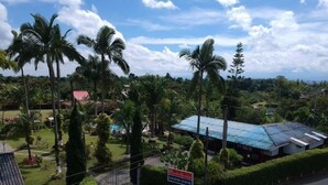 Un hotel con techo azul, rodeado de palmeras y vegetación.
